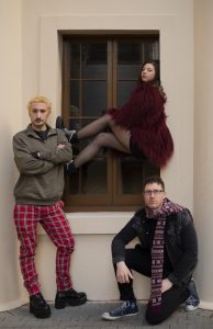 Three of the cast members from RENT standing outside the Queens Theatre